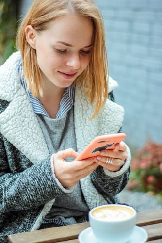 job étudiant : une jeune femme en train d'utiliser son smartphone