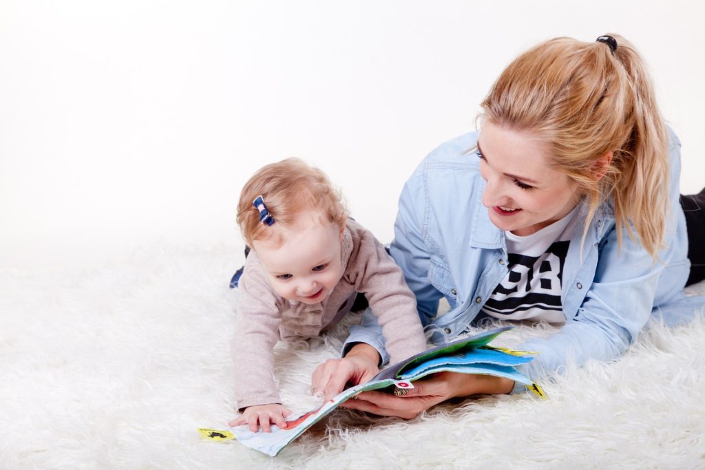 a babysitter having fun with the baby she is looking after 