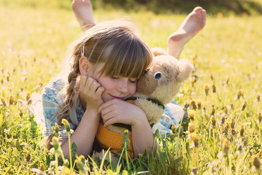 after-school care: a little girl having fun with her stuffed animal 