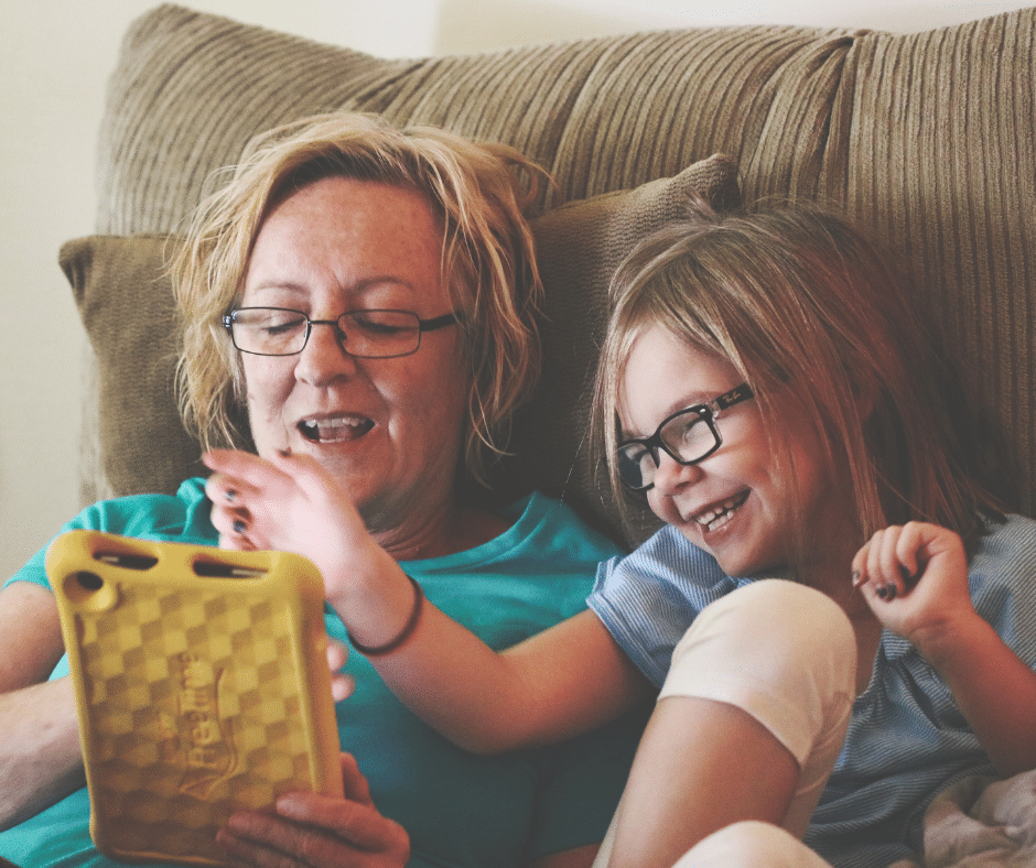 a mother having fun with her daughter using a digital tablet