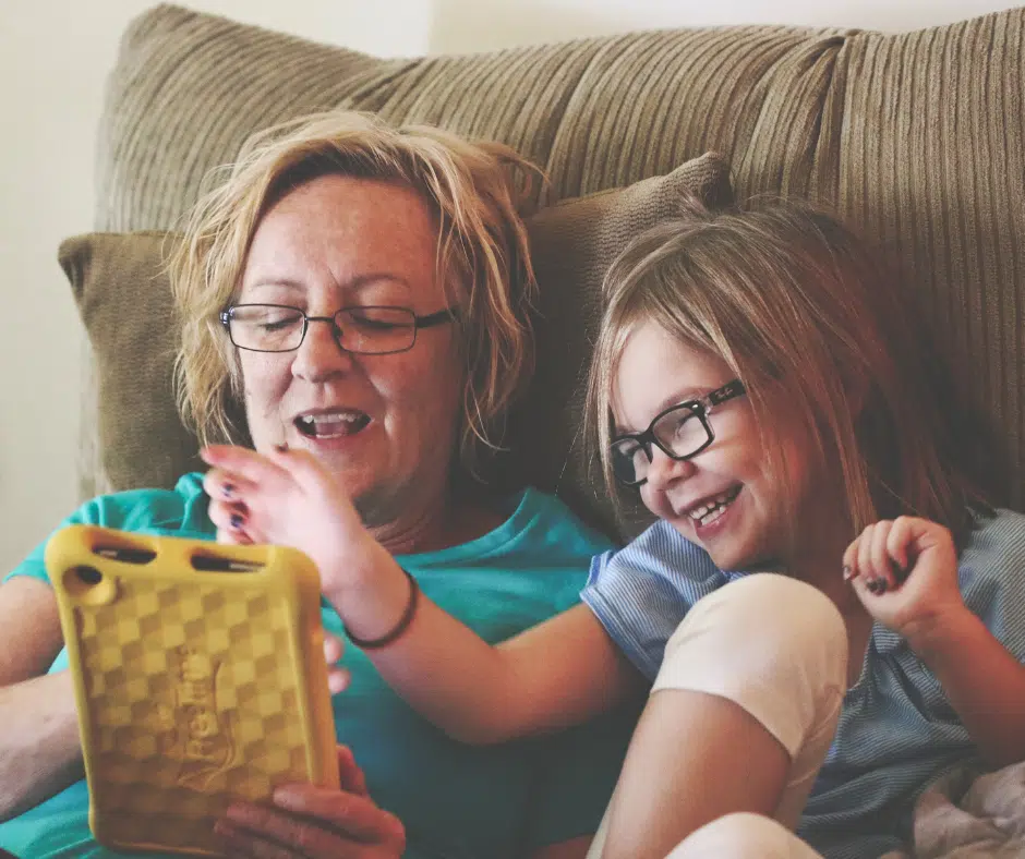 une maman qui s'amuse avec sa fille en utilisant une tablette digitale 