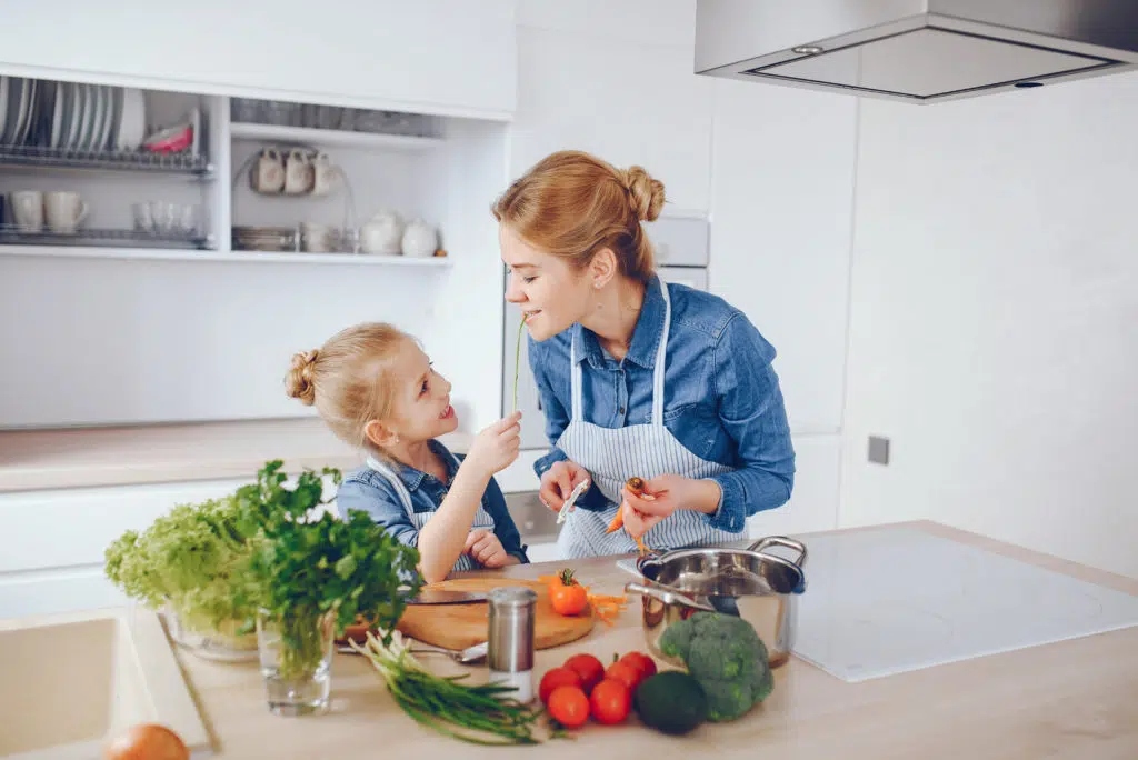 Child refuses to eat: a little girl cooking with her babysitter 