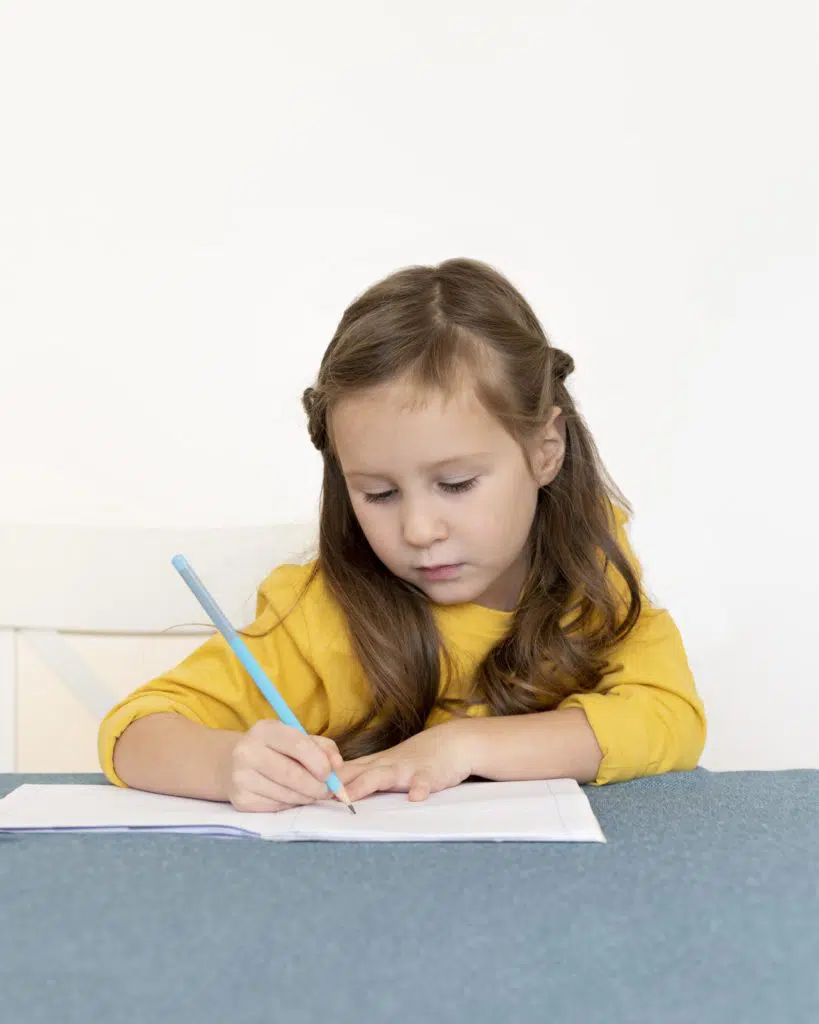 Aide aux devoirs : petite fille qui fait ses devoirs 