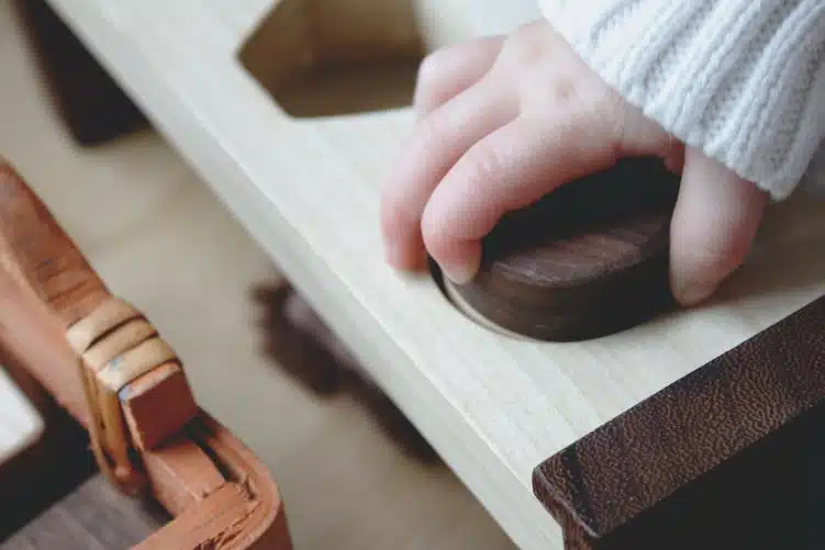 Montessori pedagogy: hand of a child on a Montessori tool 