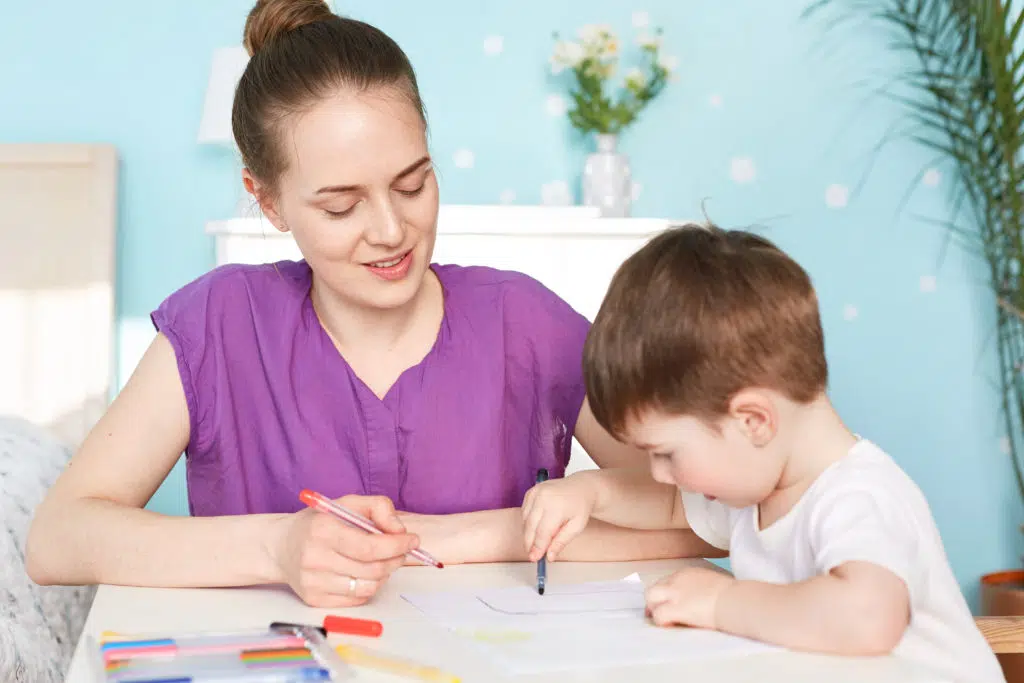 babysitter qui dessine avec un enfant 