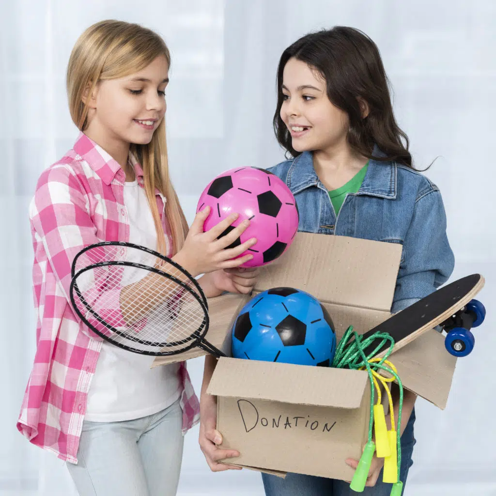 two preteens who are about to give away a whole box of toys 