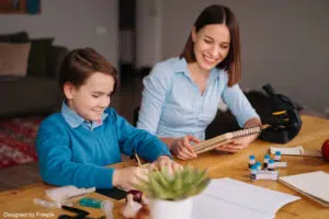 Babysitter étudiante en train d'aider l'enfant à faire ses devoirs
