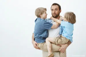 Child care at home : A father who holds his two boys in his arms