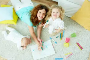 Garde d'enfant Paris : babysitter en train de colorier avec les enfants 