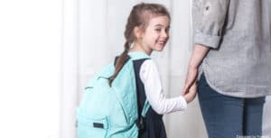 Une baby sitter qui récupère un enfant à sa sortie d'école