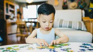 activités d'éveil : un enfant en train de faire un puzzle