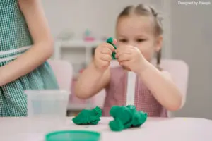 activités d'éveil : une fille en train de jouer avec la pâte à modeler