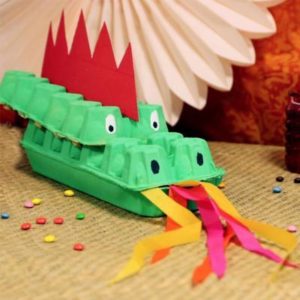 Un dragon avec des boites d'oeufs pour la journée mondiale du recyclage